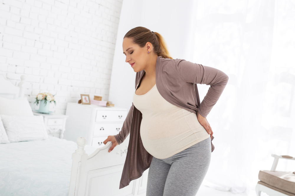 Imagem de uma mulher gravida com dores na coluna